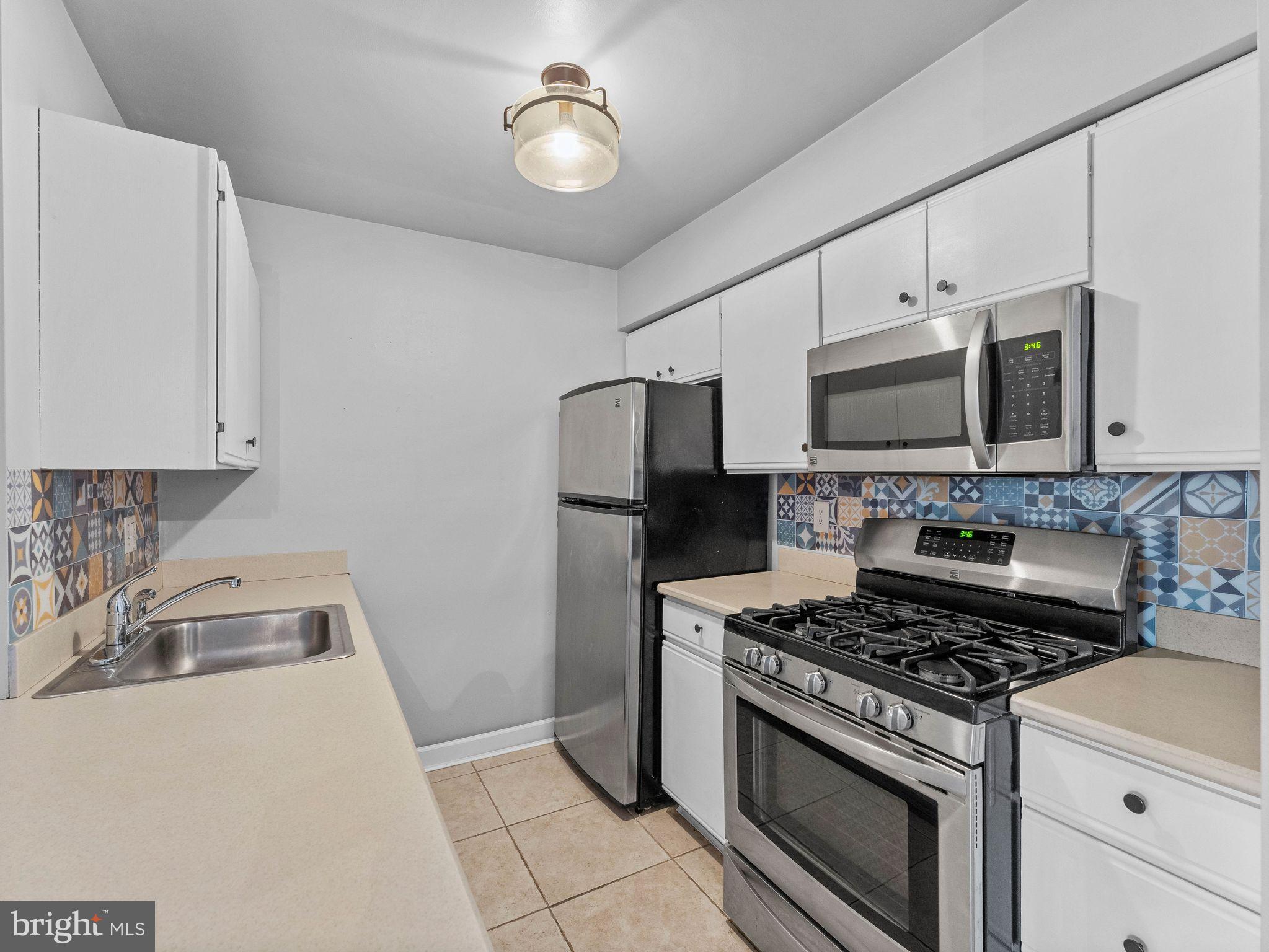 439 Glassboro Road Woodbury Heights, NJ 08097 - Photo 10 of 22 a kitchen with stainless steel appliances a stove a microwave and sink