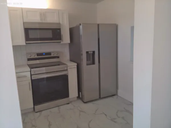 a kitchen with granite countertop white cabinets and stainless steel appliances