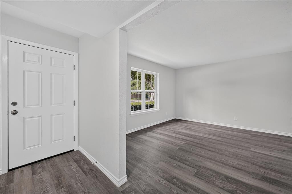 1801 East Grauwyler Road, Unit 101 Irving, TX 75061 - Photo 4 of 39 a view of an empty room with wooden floor and a window