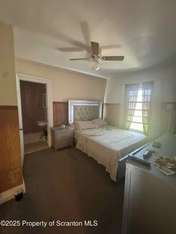 a spacious bedroom with a bed and a chandelier