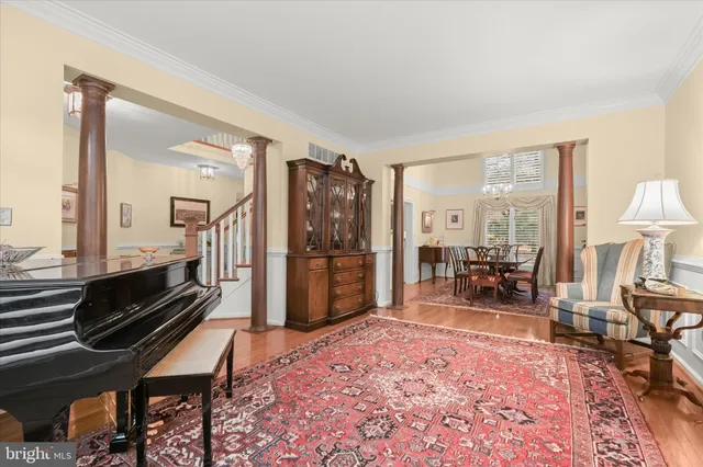 a living room with furniture a large window and stainless steel appliances