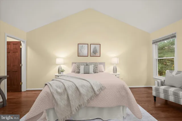 a spacious bedroom with a bed and wooden floor