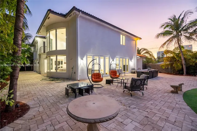 a view of a house with backyard and sitting area