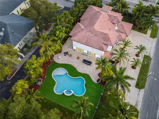 an aerial view of yellow house with an outdoor space