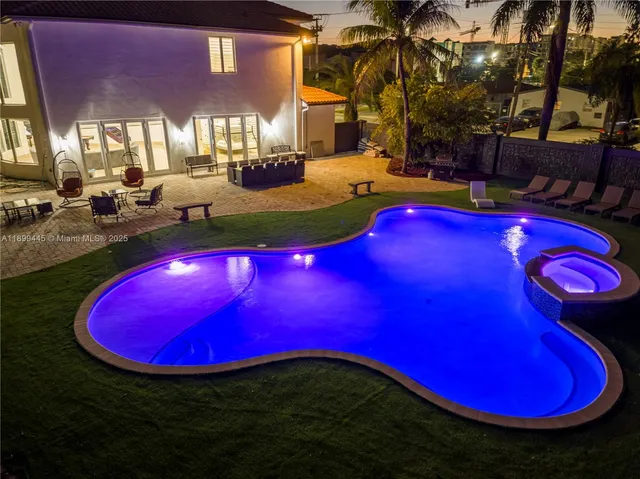 a view of a pool with table and chairs