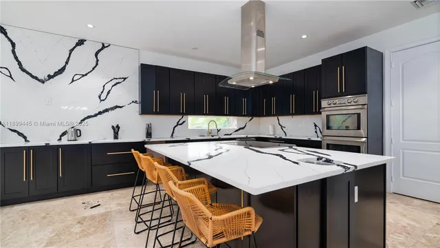 a kitchen with stainless steel appliances kitchen island granite countertop a table chairs and a wooden cabinets