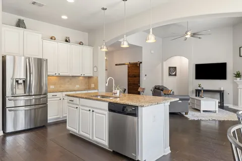 a kitchen with a sink stainless steel appliances and white cabinets