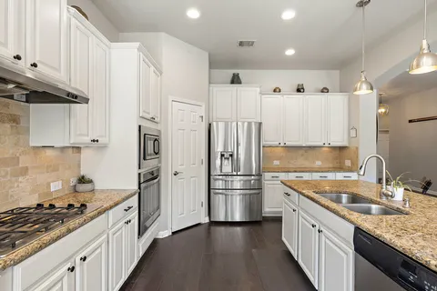 a kitchen with stainless steel appliances granite countertop a sink stove and refrigerator