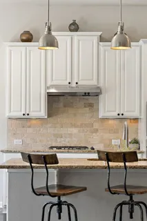 a kitchen with a white table chairs and a white wooden cabinets