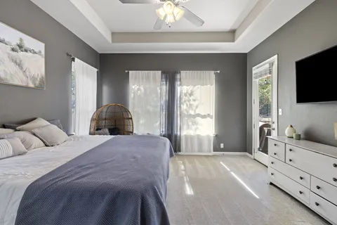 a spacious bedroom with a bed and a flat screen tv