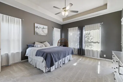 a spacious bedroom with a large bed and a chandelier