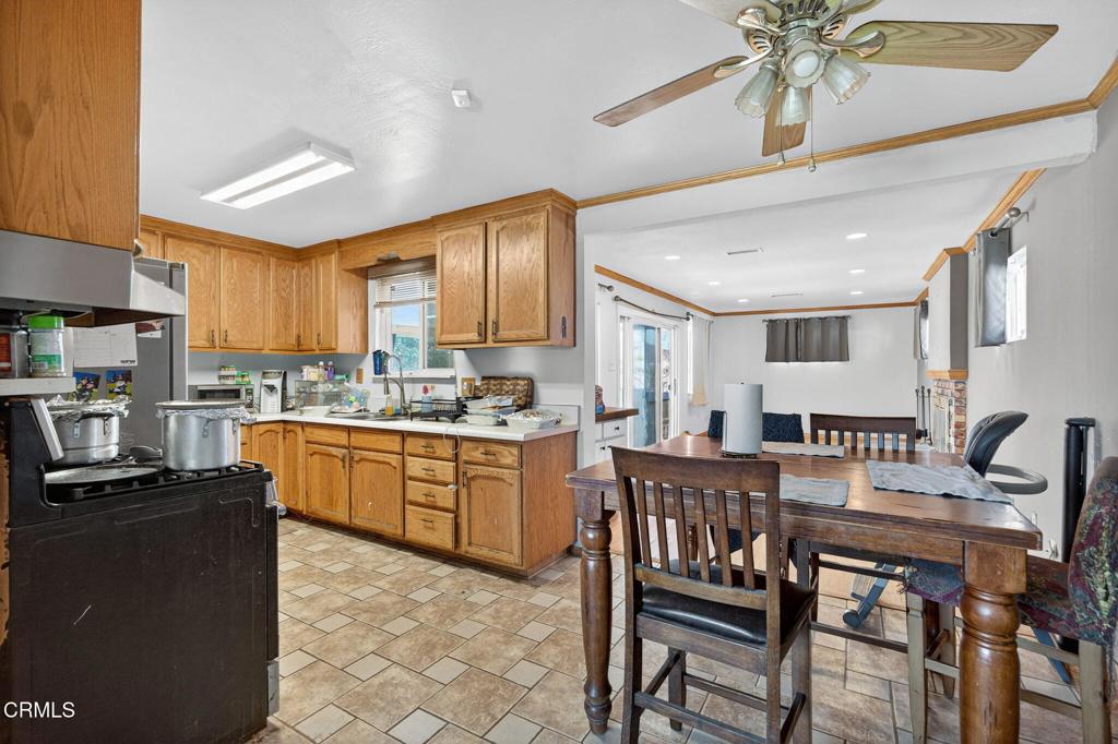 4105 South J Street Oxnard, CA 93033 - Photo 8 of 26 a kitchen with stainless steel appliances granite countertop a stove top oven a sink a dining table and chairs with wooden floor
