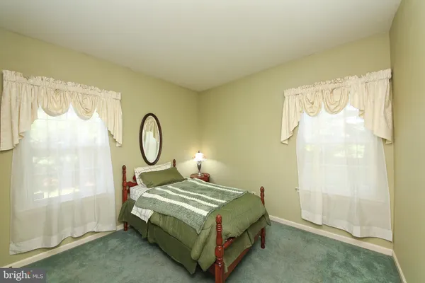 a bedroom with a bed window and a mirror