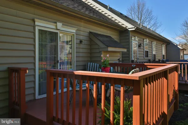 a view of wooden house with large window and wooden fence