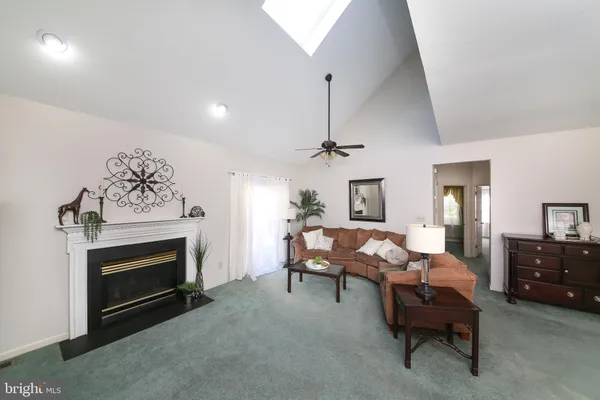 a living room with furniture a fireplace and a chandelier