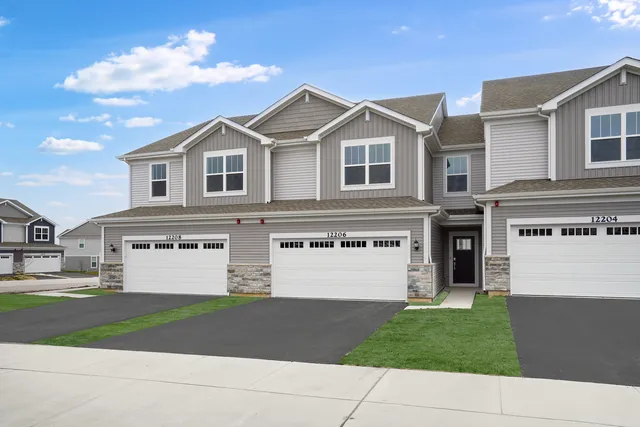 a view of a white house with a yard and large windows