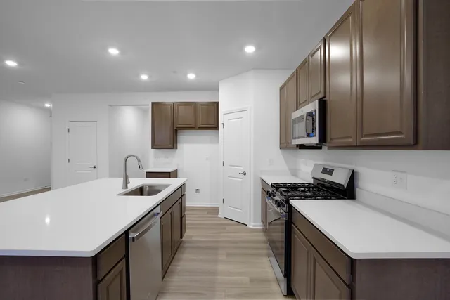 a kitchen with stainless steel appliances a sink stove and microwave