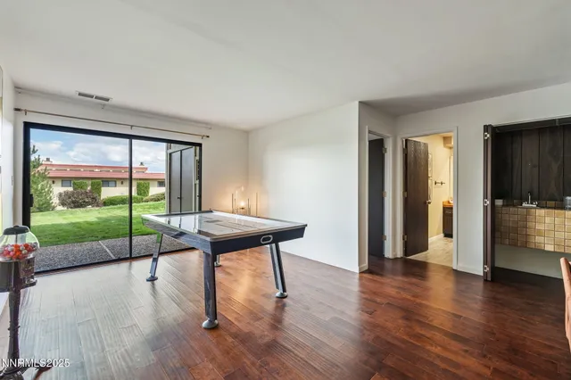 a view of a livingroom with furniture wooden floor and a floor to ceiling window