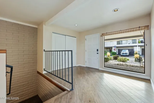 a view of a hallway with wooden floor and dining room