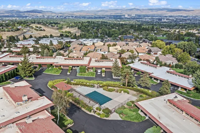 an aerial view of residential houses with outdoor space and parking