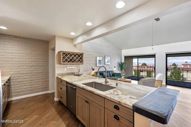 a kitchen with stainless steel appliances granite countertop a sink counter space cabinets and a couch