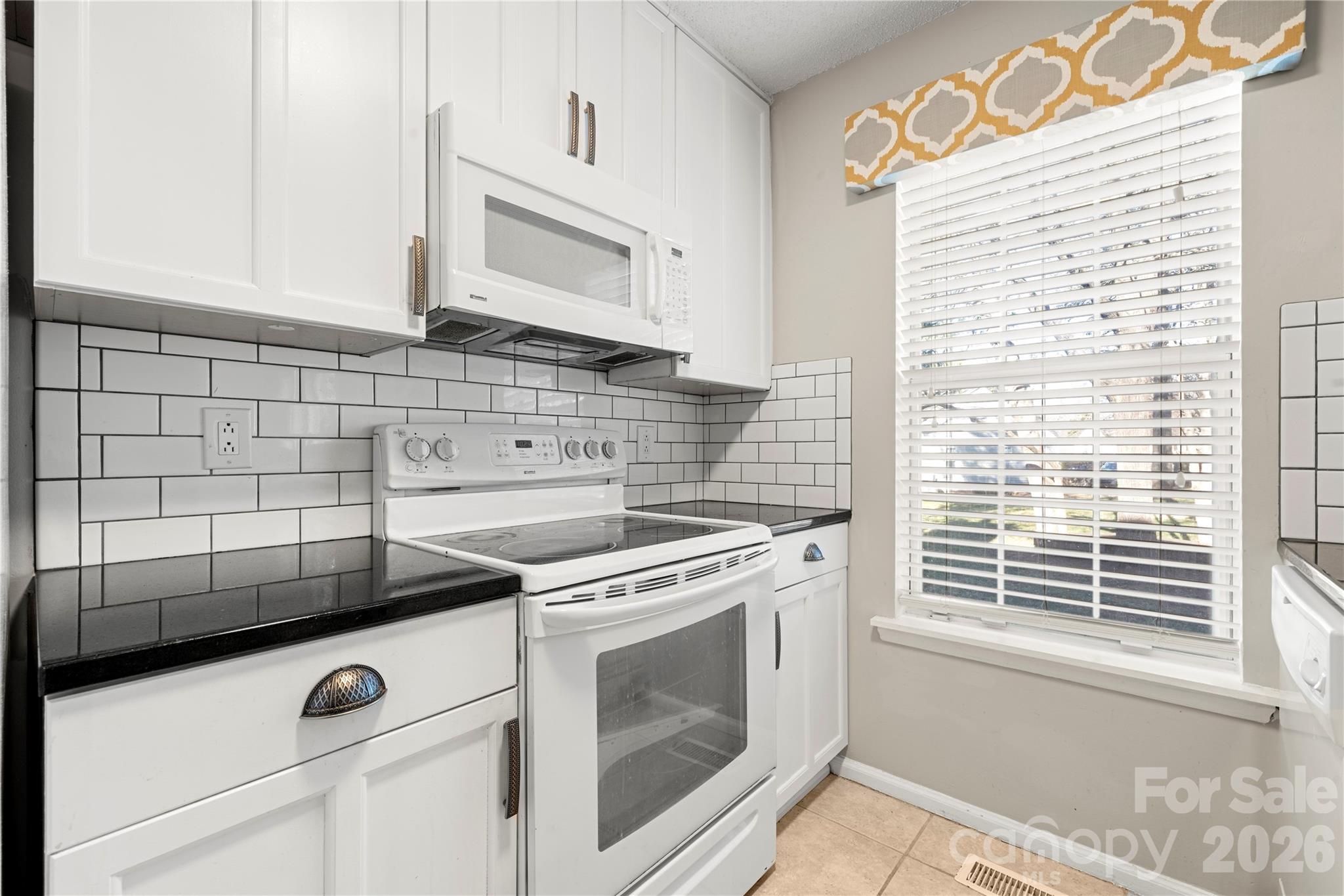 8240 Circle Tree Lane Charlotte, NC 28277 - Photo 11 of 29 a kitchen with a stove and white cabinets