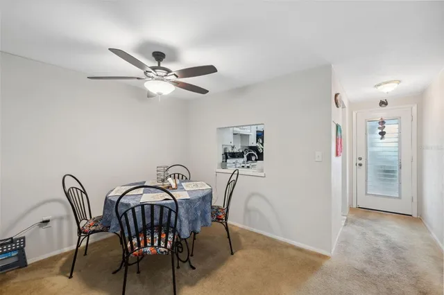 a view of a dining room with furniture and a chandelier fan