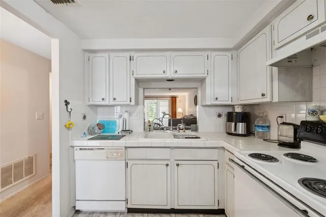a kitchen with white cabinets and white appliances