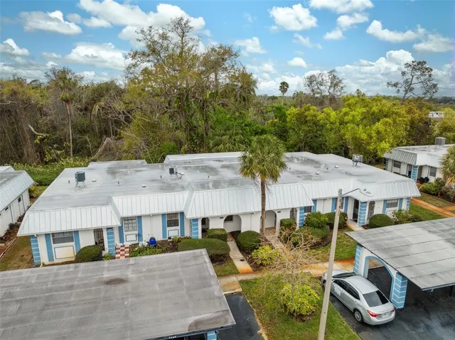 a aerial view of a house with swimming pool and large trees