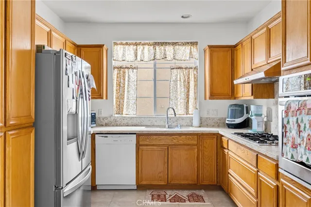 a kitchen with stainless steel appliances granite countertop a sink a stove and a refrigerator