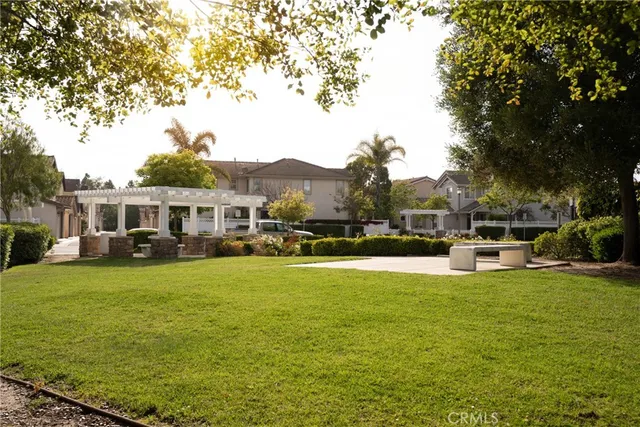 a view of a white house with a big yard and large trees
