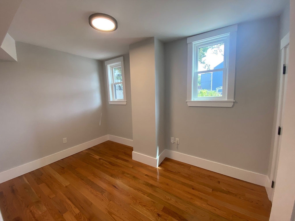 120 Marginal Street, Unit 1 Boston, MA 02128 - Photo 12 of 18 an empty room with wooden floor and windows