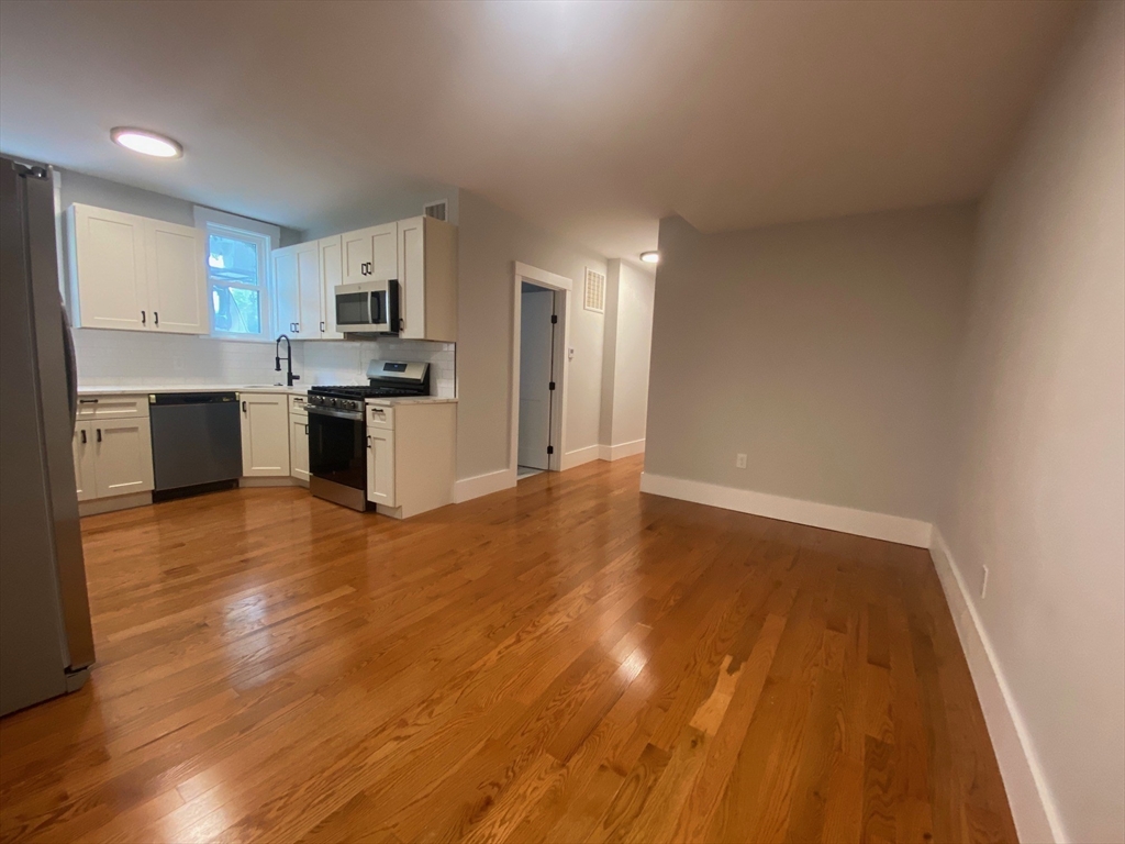120 Marginal Street, Unit 1 Boston, MA 02128 - Photo 2 of 18 a view of a kitchen with a sink and dishwasher a refrigerator with wooden floor