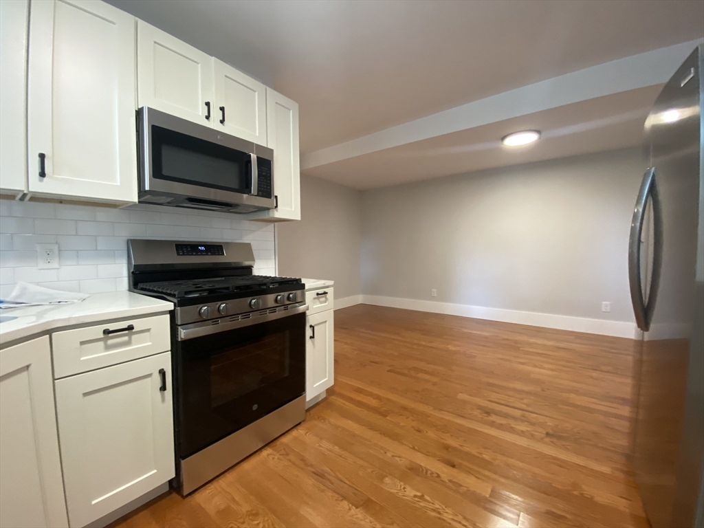 120 Marginal Street, Unit 1 Boston, MA 02128 - Photo 3 of 18 a kitchen with stainless steel appliances granite countertop a stove a sink and a microwave
