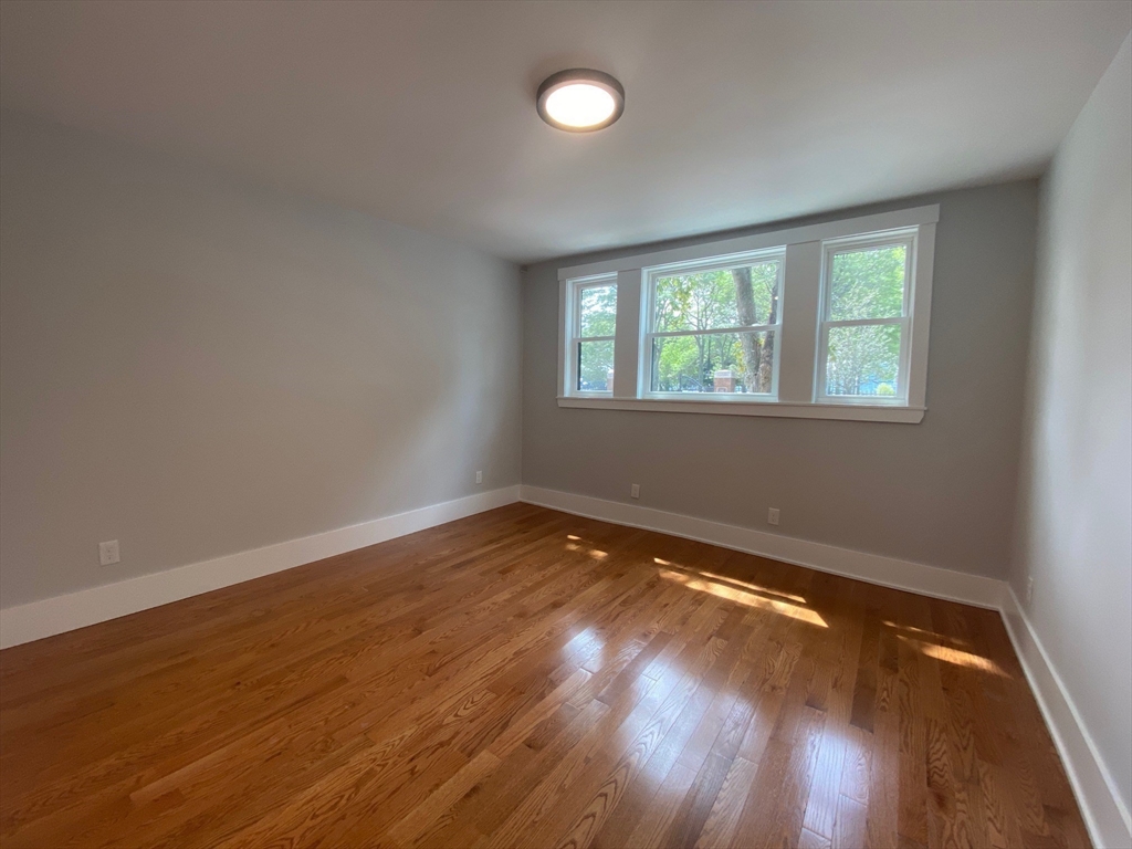 120 Marginal Street, Unit 1 Boston, MA 02128 - Photo 5 of 18 an empty room with wooden floor and windows