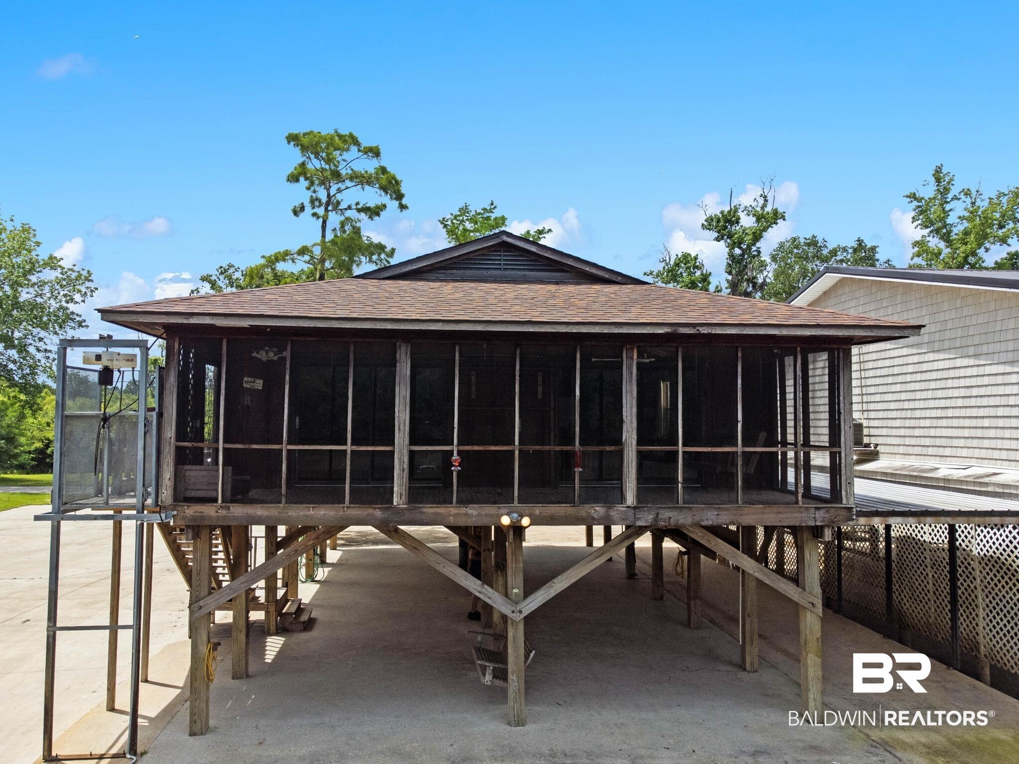 8153 Bryant's Lndg Road Stockton, AL 36579 - Photo 54 of 87 Elevated property featuring a screened porch, exposed wooden pilings, and a concrete pad beneath