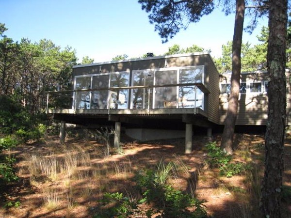 150 Anawan Road Wellfleet, MA 02667 - Photo 2 of 27 a view of a large building with a small yard and large trees
