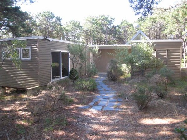 150 Anawan Road Wellfleet, MA 02667 - Photo 7 of 27 a view of a small yard in front of a house with large trees