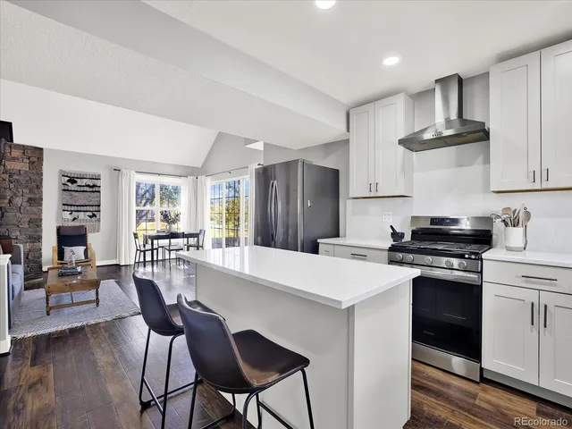 a kitchen with stainless steel appliances a table chairs and a refrigerator