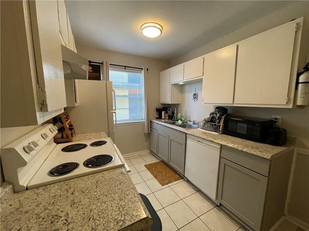 4302 Lake Road, Unit 4 Killeen, TX 76543 - Photo 3 of 9 Kitchen with wall chimney range hood, white appliances, sink, gray cabinetry, and light tile patterned flooring
