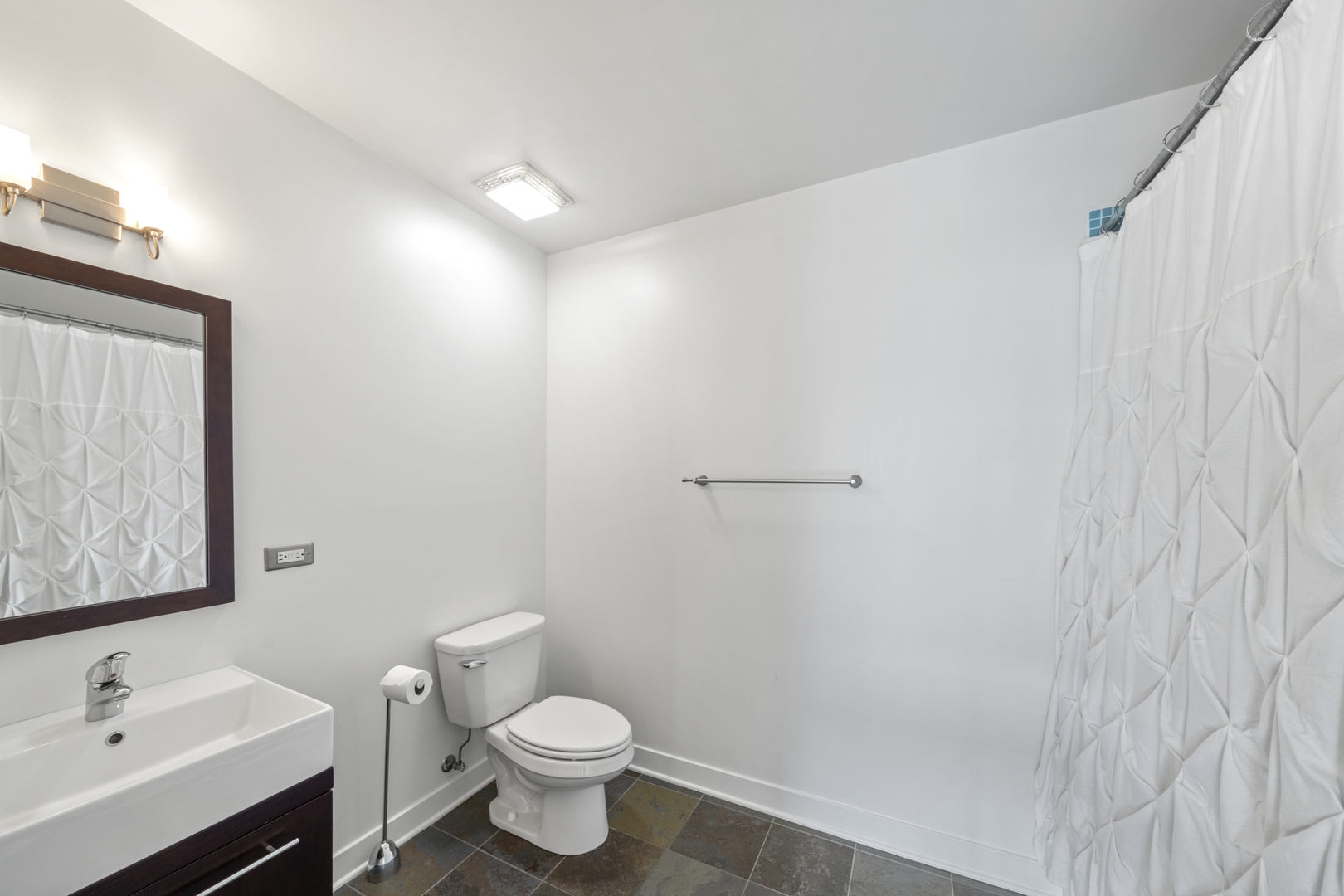 660 West Wayman Street, Unit 201B Chicago, IL 60661 - Photo 23 of 34 a bathroom with a sink mirror vanity and toilet