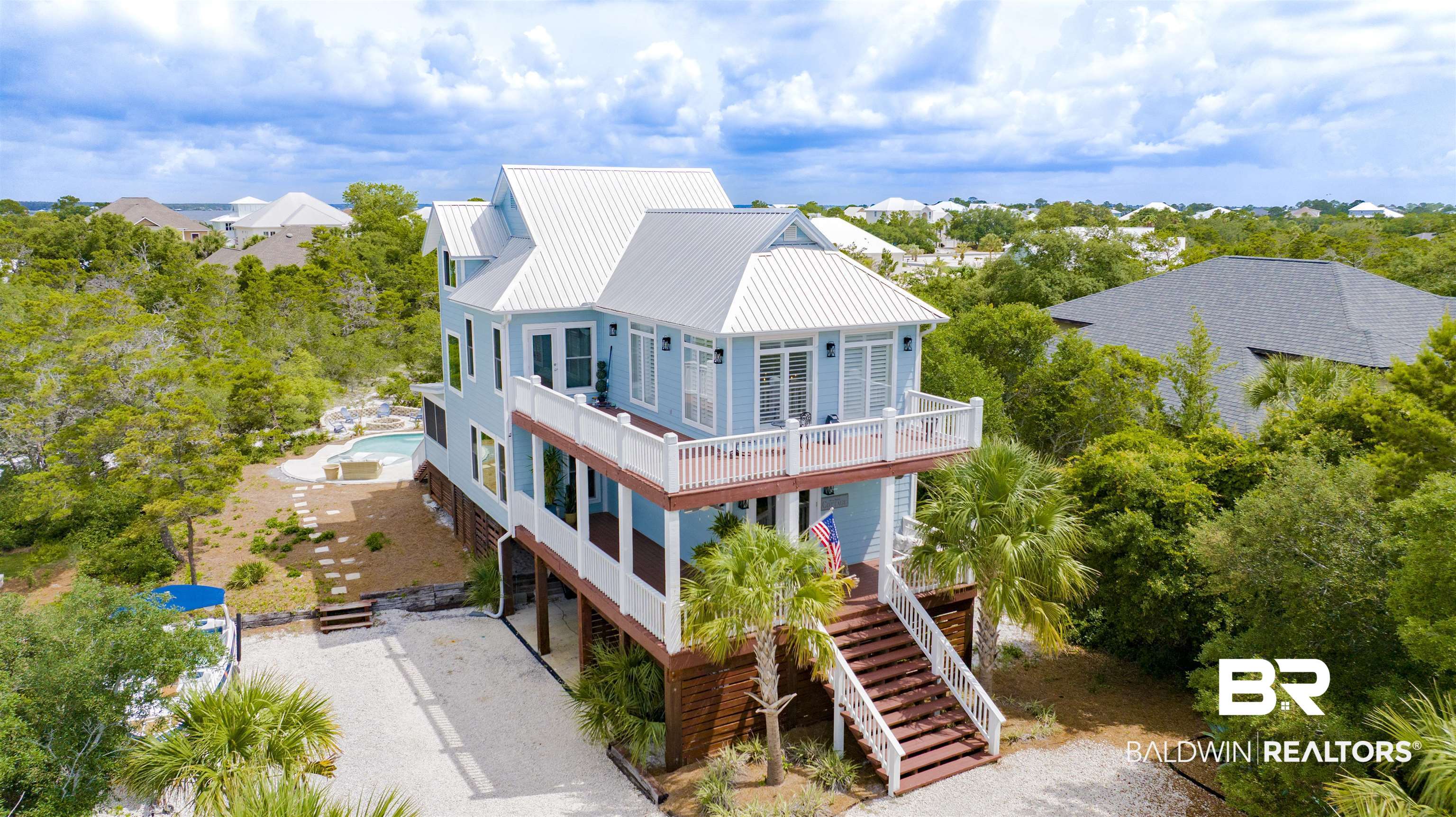 30351 River Road Orange Beach, AL 36561 - Photo 1 of 44 Light blue multi-story residence with a metal roof and elevated decks