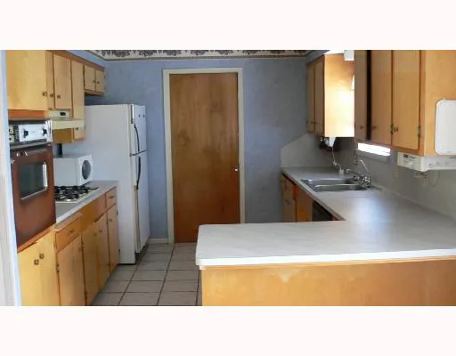 a kitchen with stainless steel appliances kitchen island a sink stove and refrigerator