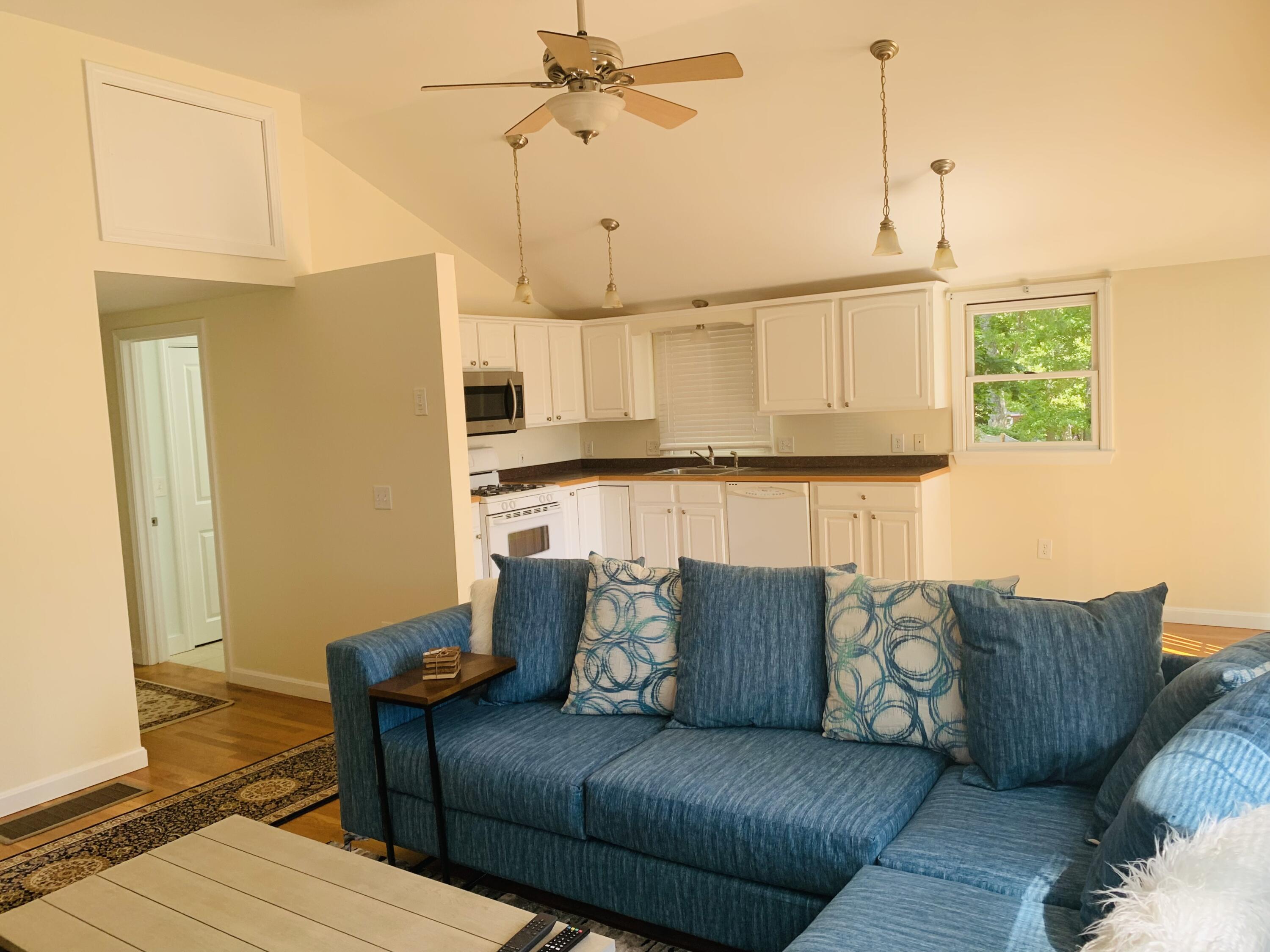 58 Buccaneer Way Mashpee, MA 02649 - Photo 5 of 8 a living room with furniture and a chandelier