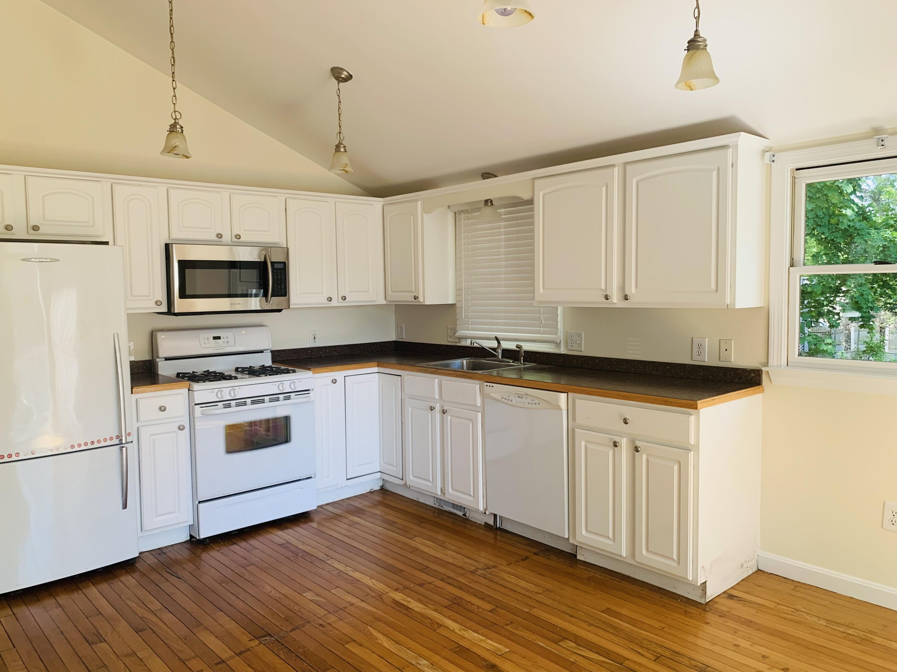 58 Buccaneer Way Mashpee, MA 02649 - Photo 8 of 8 a kitchen with granite countertop a stove a sink and a microwave