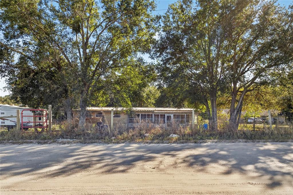 38710 Townsend Road Dade City, FL 33525 - Photo 3 of 17 a view of a backyard with large trees and wooden fence