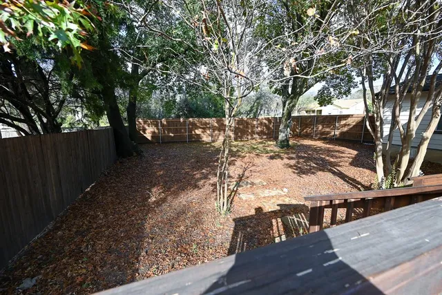 a view of a yard with wooden fence