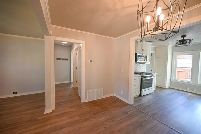 an empty room with wooden floor and entrance
