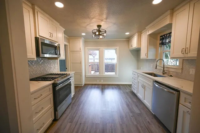 a kitchen with a wooden floor stove top oven and sink