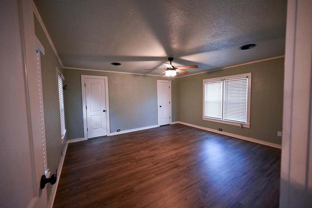 1300 South Trinity Street Decatur, TX 76234 - Photo 7 of 18 a view of an empty room with wooden floor and a window